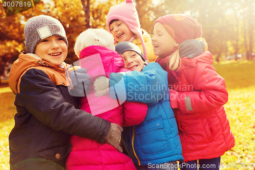 Image of group of happy children hugging in autumn park