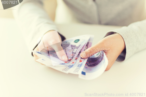 Image of close up of woman hands counting euro money