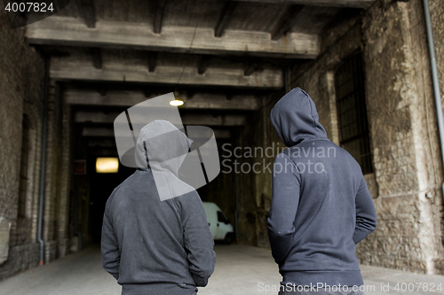 Image of addict men or criminals in hoodies on street