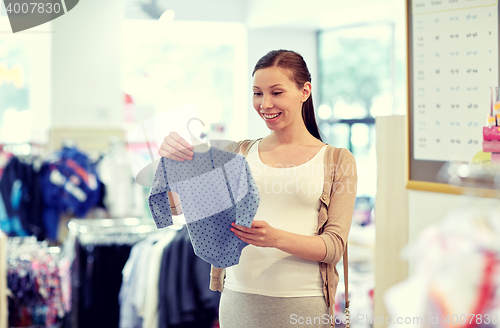 Image of happy pregnant woman shopping at clothing store