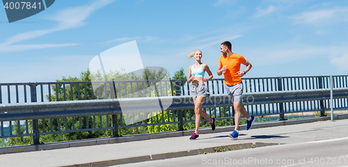 Image of smiling couple running at summer seaside