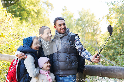 Image of family with backpacks taking selfie and hiking