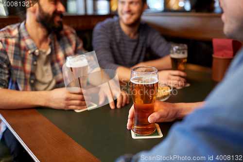 Image of happy male friends drinking beer at bar or pub