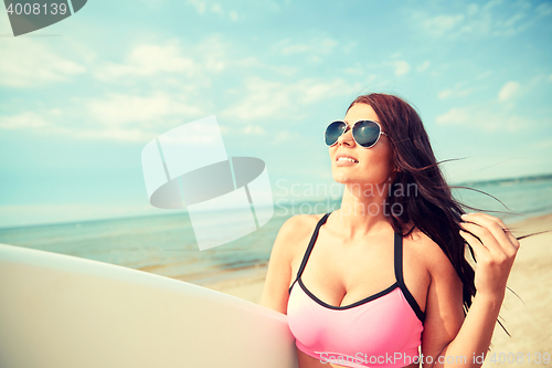 Image of smiling young woman with surfboard on beach