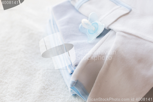 Image of close up of baby clothes for newborn and soother