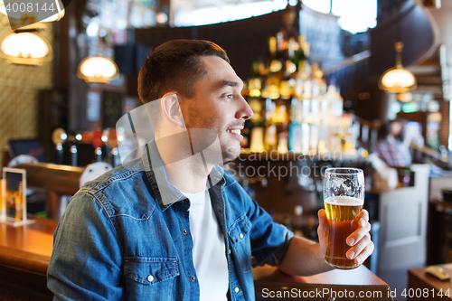 Image of happy man drinking beer at bar or pub