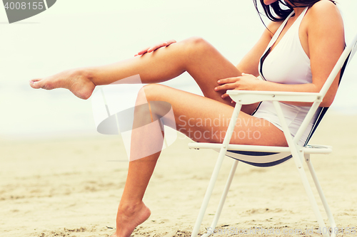 Image of close up of woman sunbathing in lounge on beach