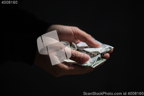 Image of close up of addict hands with drugs and money
