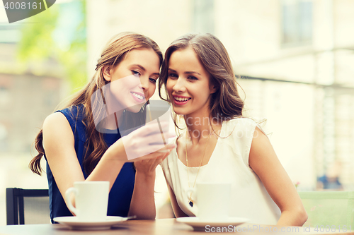 Image of young women with smartphone and coffee at cafe