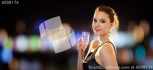 Image of young asian woman drinking champagne at party