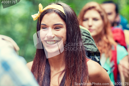 Image of group of smiling friends with backpacks hiking