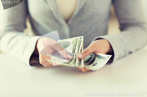 Image of close up of woman hands counting us dollar money