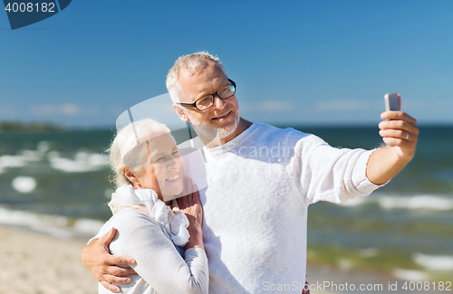 Image of happy senior couple hugging on summer beach