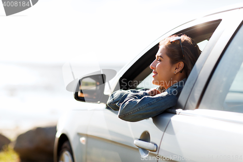 Image of happy teenage girl or young woman in car