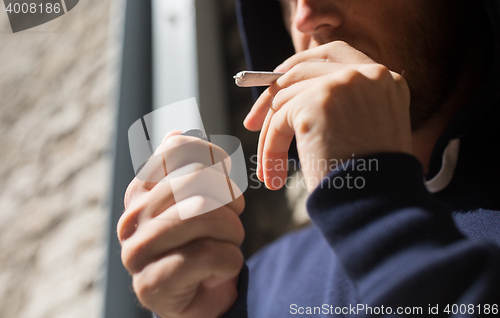 Image of close up of addict smoking marijuana joint