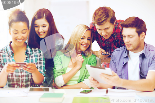 Image of students looking at smartphones and tablet pc