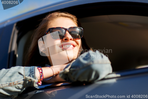 Image of happy teenage girl or young woman in car