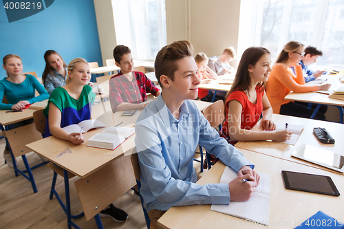 Image of group of students with notebooks at school lesson