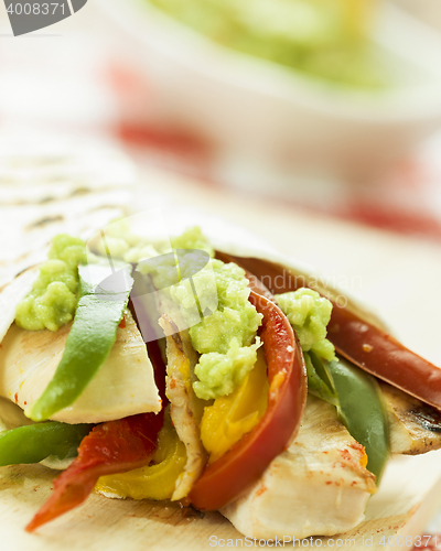 Image of delicious wrap tortilla with spicy chicken vegetables guacamole