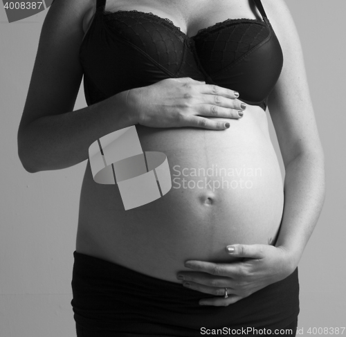 Image of Pregnant Woman holding her hands on beautiful belly
