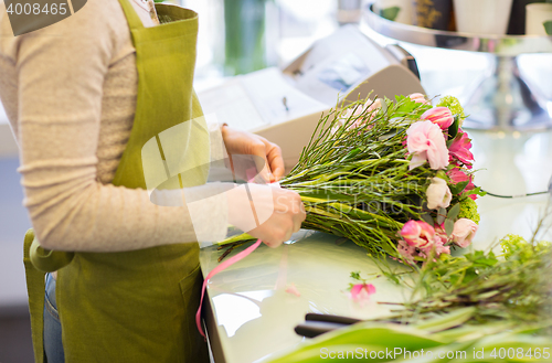 Image of close up of woman making bunch at flower shop