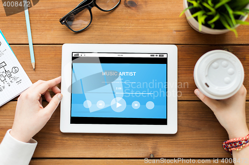 Image of close up of woman with tablet pc on wooden table