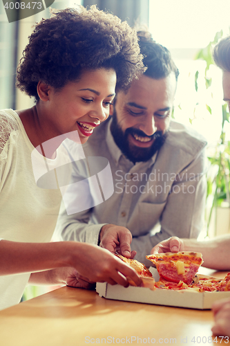 Image of happy business team eating pizza in office