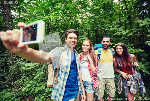 Image of friends with backpack taking selfie by smartphone