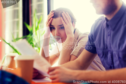 Image of creative team with reading paper in office