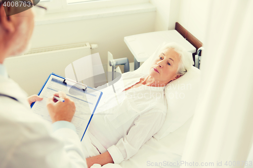 Image of senior woman and doctor with clipboard at hospital