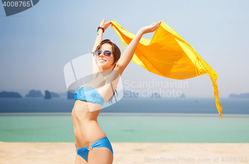 Image of woman in bikini and sunglasses over infinity pool