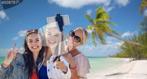 Image of group of smiling women taking selfie on beach