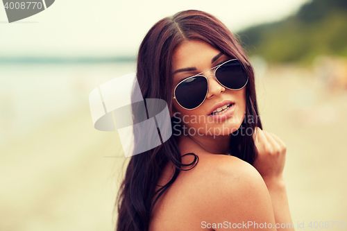 Image of young woman with sunglasses on beach