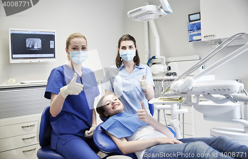 Image of happy female dentist with patient girl at clinic