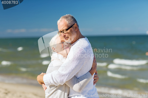 Image of happy senior couple hugging on summer beach