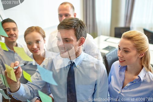 Image of smiling business people with marker and stickers