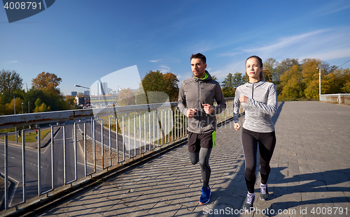 Image of happy couple running outdoors