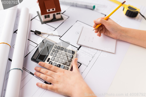 Image of close up of architect hand counting on calculator