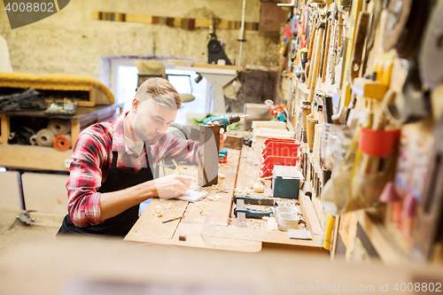 Image of carpenter working with wood plank at workshop