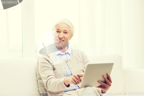 Image of happy senior woman with tablet pc at home