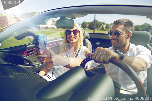 Image of happy couple using gps navigator in cabriolet car