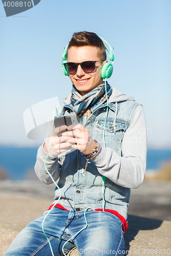 Image of happy young man in headphones with smartphone