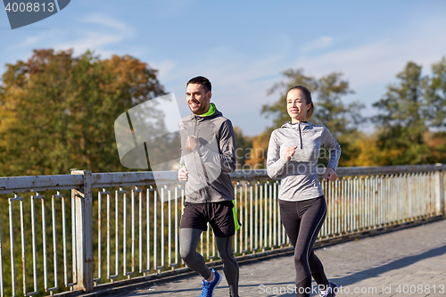 Image of happy couple running outdoors