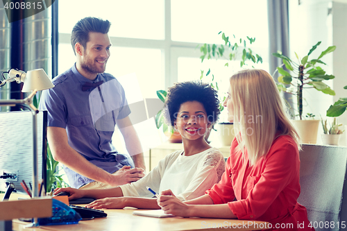 Image of happy creative team talking in office