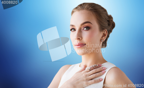 Image of smiling woman in white dress with diamond jewelry