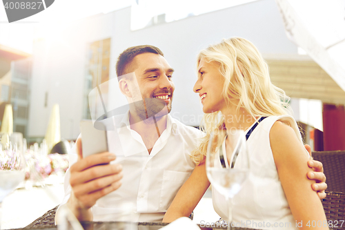 Image of couple taking selfie with smatphone at restaurant