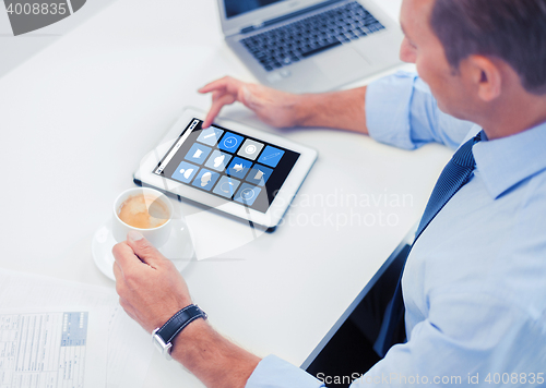Image of businessman with app icons on tablet pc and coffee