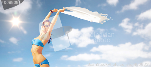 Image of woman in bikini and sunglasses over blue sky