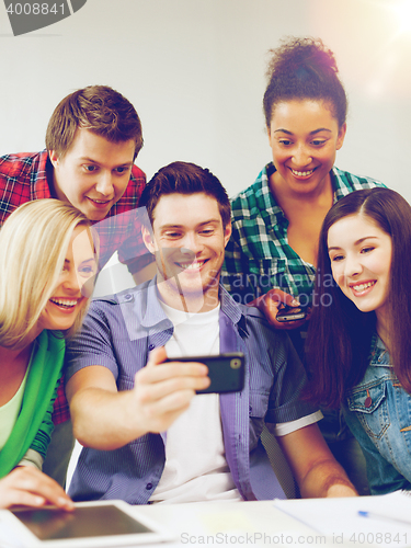 Image of students looking into smartphone at school