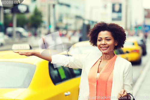 Image of happy african woman catching taxi